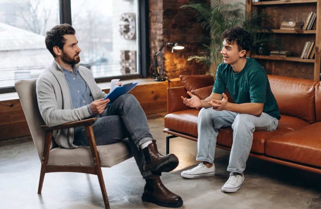 A young man talks to his therapist during rehab for college students in Philadelphia.