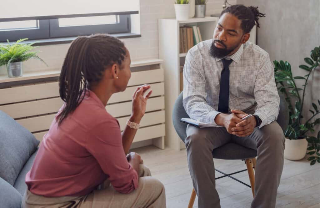 A woman talks to her therapist about healthy coping mechanisms during Philadelphia rehab for executives and CEOs.