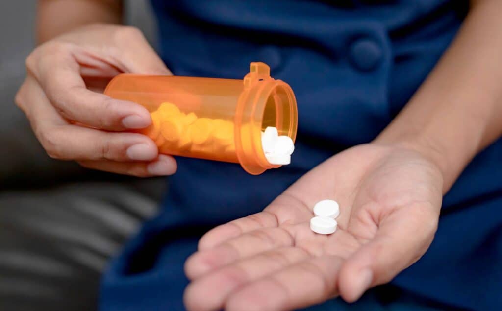 Person taking pills while struggling with Xanax addiction.