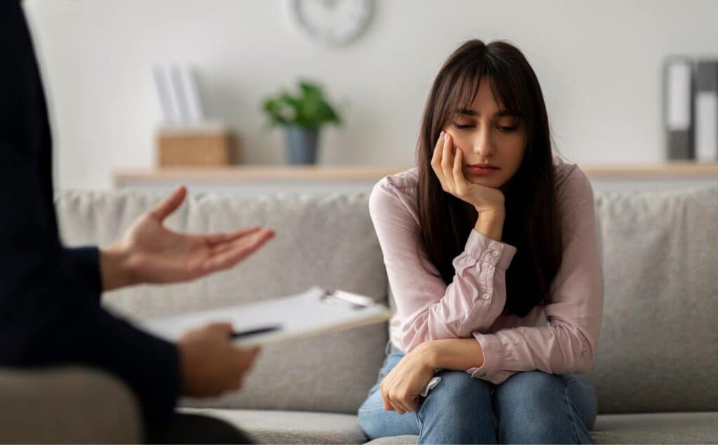 Woman listening quietly in a counseling session for dual diagnosis treatment in Philadelphia, PA.