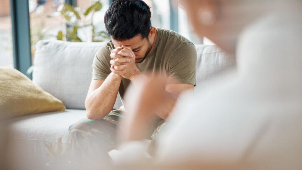 Man opening up to a therapist in a private trauma-informed addiction treatment session.