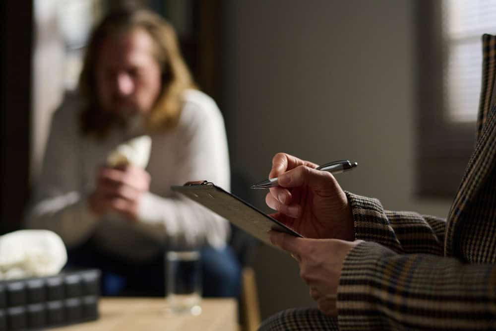 Clinician taking notes during hydrocodone addiction treatment in Philadelphia consultation