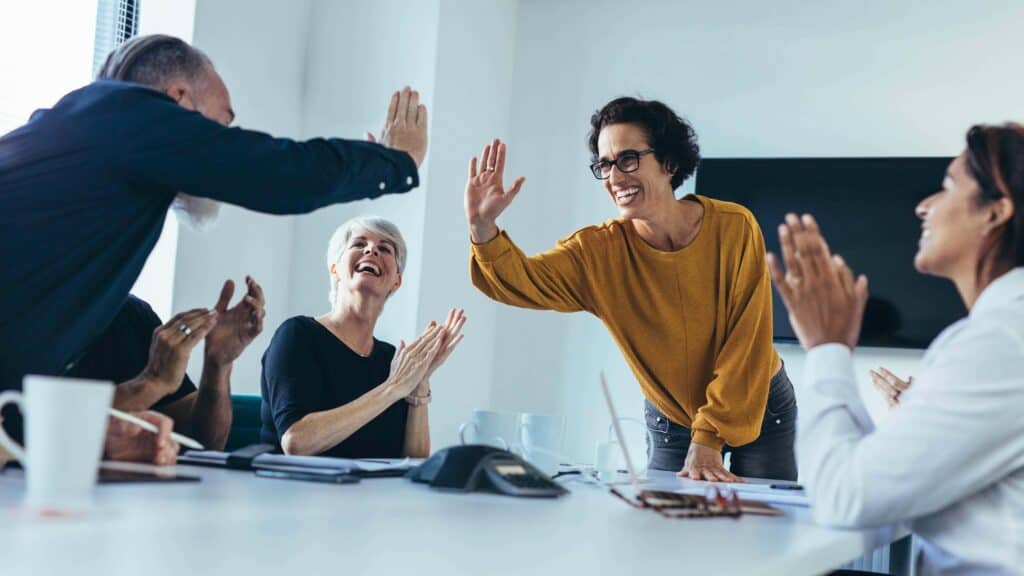 Team celebrating workplace success while supporting recovery during long-term rehab