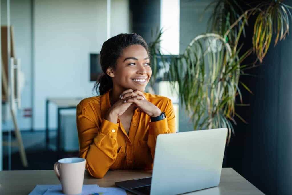Businesswoman working at a laptop while considering work during rehab for alcoholism