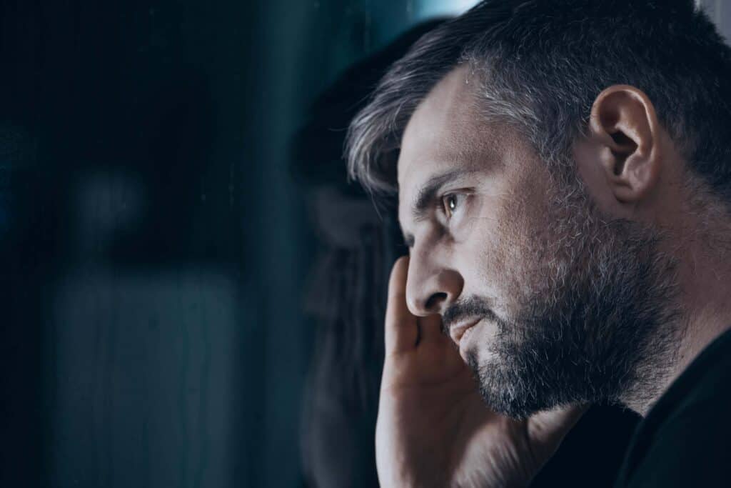 Thoughtful man experiencing substance abuse and anxiety during recovery